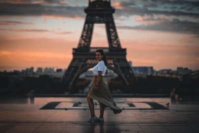 选择聚焦摄影的女人站在埃菲尔铁塔前,巴黎
